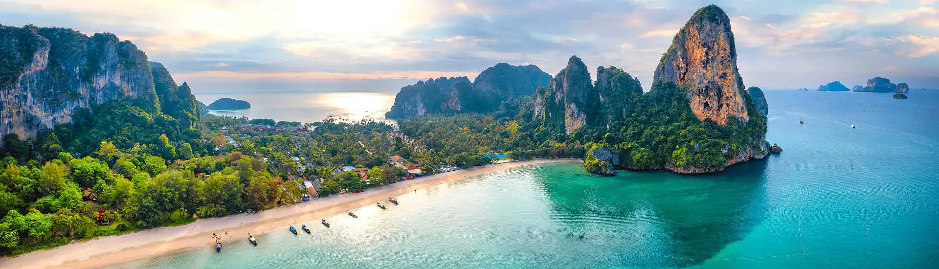 Thailand Reisen mit AsiaGo: Malerische Bucht in Krabi mit türkisblauem Wasser, weißen Sandstränden und imposanten Kalksteinfelsen