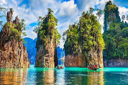 Kalksteinfelsen im Chiao-Lan-See im Khao Sok Nationalpark nahe Khao Lak mit Longtail-Booten