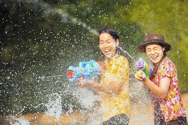 Menschen mit Wasserpistolen während der Wasserschlacht zum Songkran Festival in Thailand