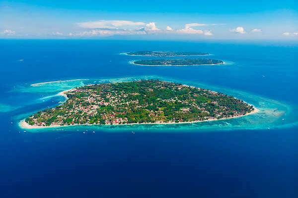 Luftaufnahme der Gili-Inseln mit türkisfarbenem Wasser und flachen Riffen vor Lombok