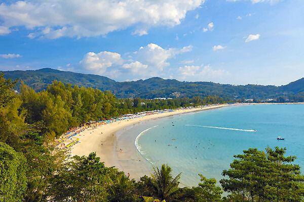 Kamala Beach auf Phuket mit geschwungener Bucht, türkisfarbenem Wasser und grünen Hügeln