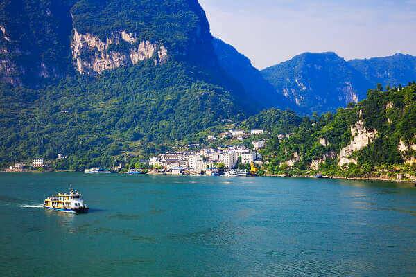 Flusskreuzfahrt auf dem Yangtze durch die Drei Schluchten mit grünem Gebirge und Küstenort in China
