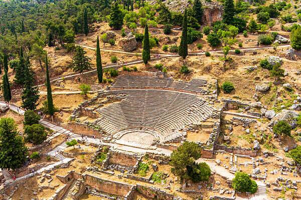 Blick auf das antike Theater von Delphi in Griechenland, umgeben von Bergen und grüner Landschaft.