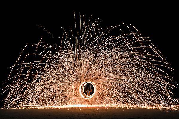 Feuershow am Pattaya Beach auf Koh Lipe bei Nacht mit Funkenflug am Strand