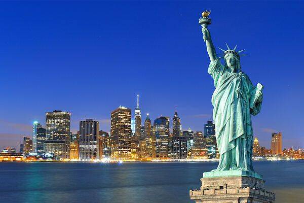 Freiheitsstatue vor der Skyline von New York bei Nacht