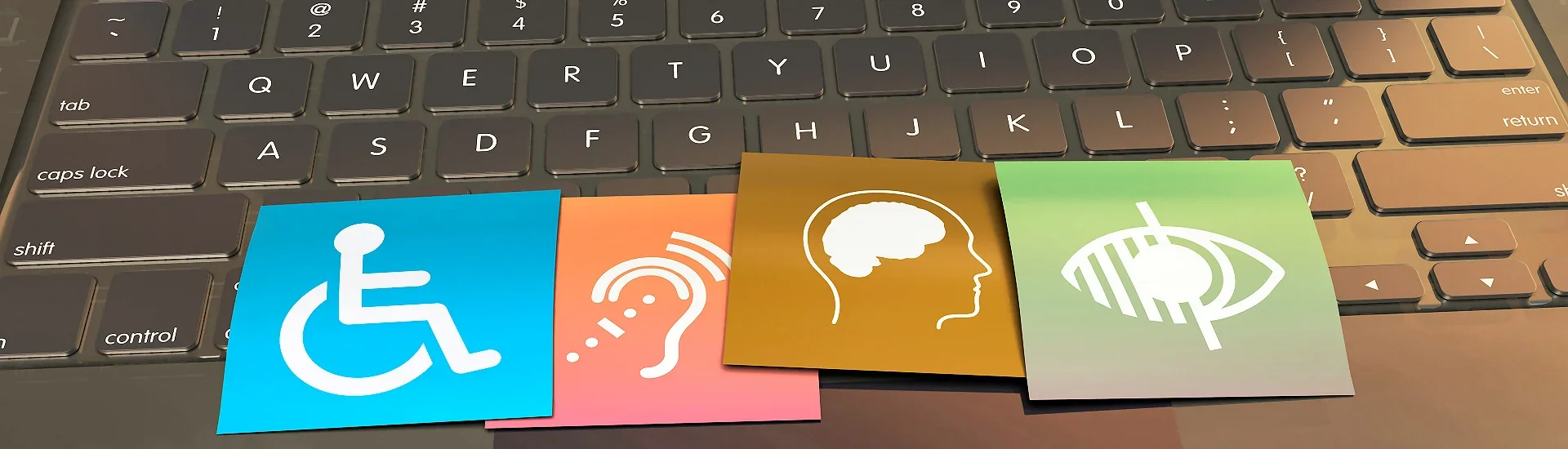 Symbole für Barrierefreiheit – Rollstuhl, Ohr, Kopf und Auge auf einer Tastatur