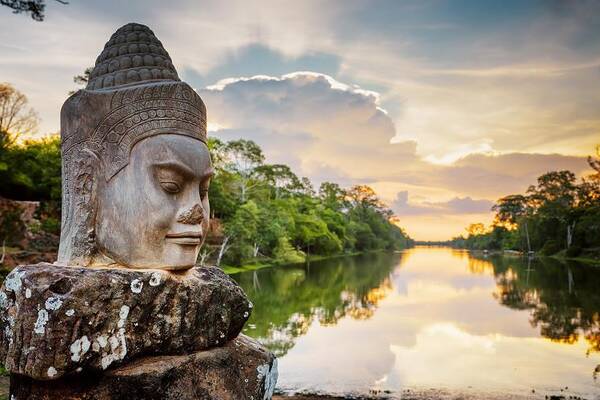 Steinerner Buddha am Fluss bei Sonnenuntergang in Kambodscha – Natur und Kultur einer Kombireise