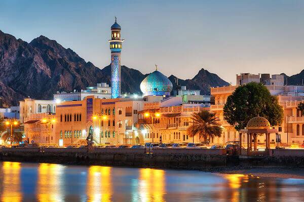 Muscat Uferpromenade im Abendlicht mit Minarett und Bergen