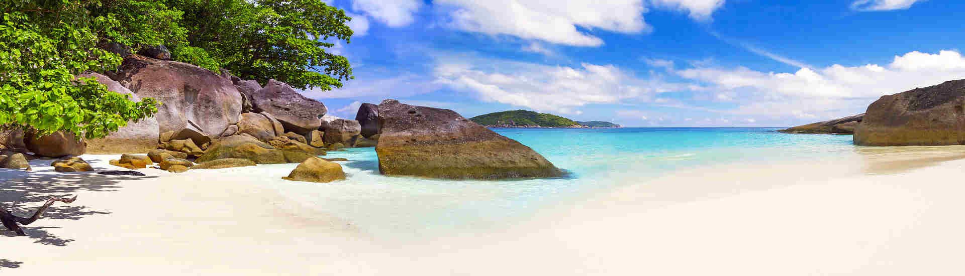 Heller Sandstrand mit Felsen und türkisfarbenem Wasser auf Koh Phangan im Golf von Thailand