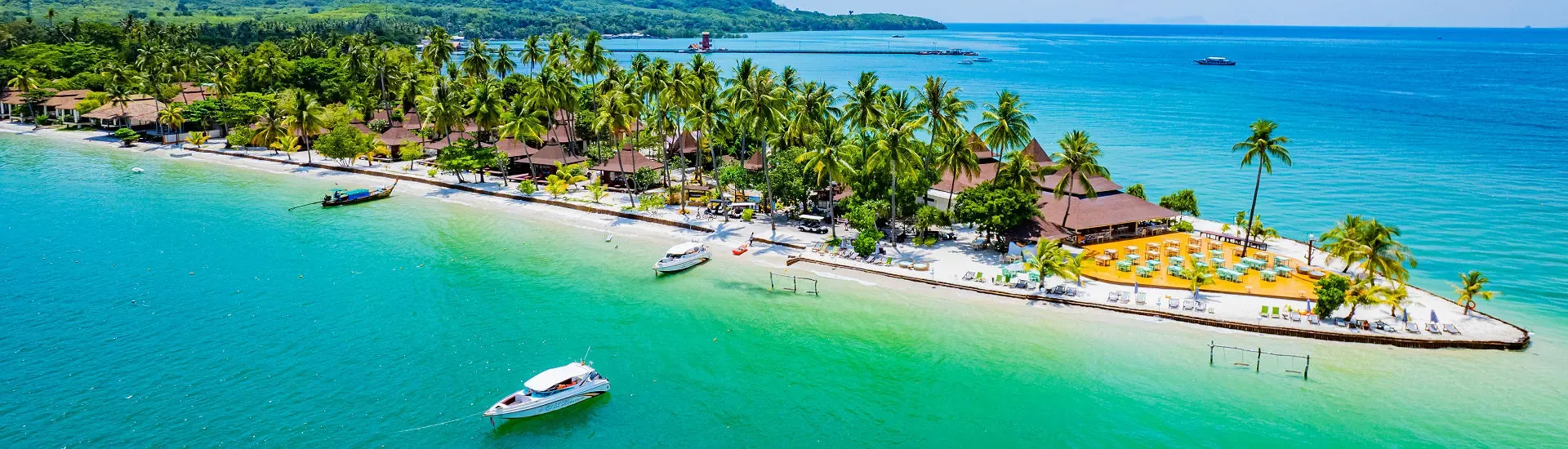 Strandresort in Thailand mit Palmen, Booten und direkter Lage am türkisfarbenen Meer