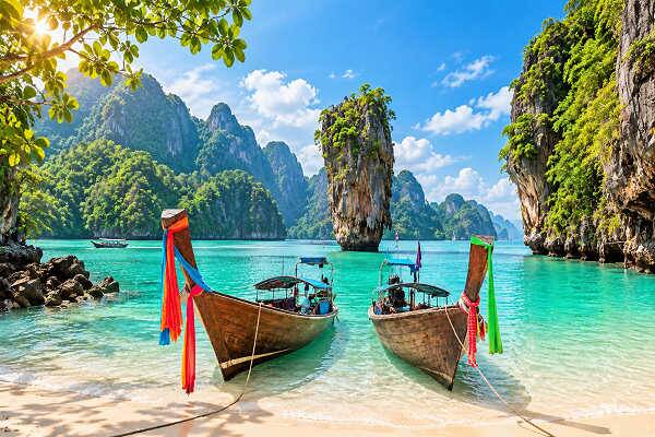 Longtail-Boote an einer tropischen Inselküste in Thailand