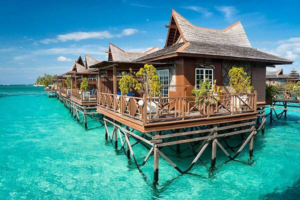 Wasserbungalows über türkisfarbenem Meer als Badeaufenthalt nach einer Malaysia Rundreise