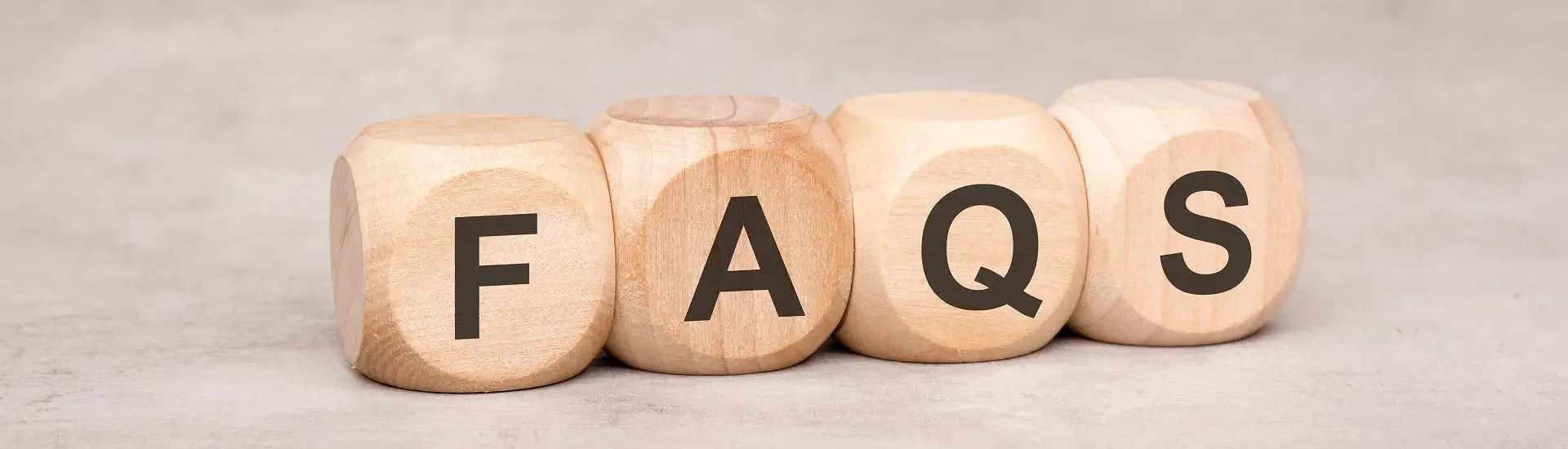 Holzblöcke mit den Buchstaben F A Q S als Symbol für häufige Fragen