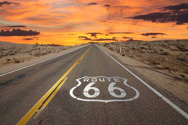 Route 66 durch eine weite Landschaft bei Sonnenuntergang