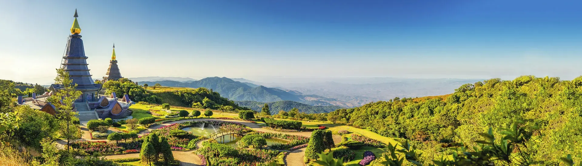 Tempelanlage in der Bergregion Nordthailands mit Blick über grüne Hügel und Berge