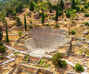 Blick auf das antike Theater von Delphi in Griechenland, umgeben von Bergen und grüner Landschaft.