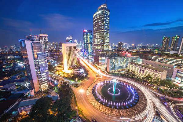 Abendliche Skyline von Jakarta mit dem Kreisverkehr Bundaran HI als Startpunkt eines Stopovers vor einer Rundreise durch Sulawesi und Badeaufenthalt auf Bali