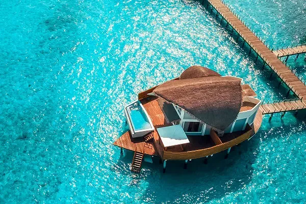 Malediven Inspiration – Luxus-Wasserbungalow im türkisblauen Meer – AsiaGo Wasserbungalow mit Pool auf Stelzen über klarem türkisblauem Meer auf den Malediven