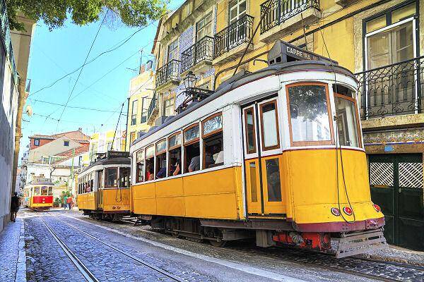 Gelbe Straßenbahn in einer Altstadtstraße von Lissabon