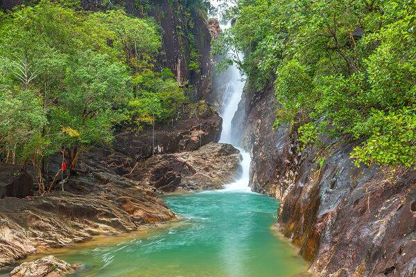 Der Klong Plu Wasserfall auf Koh Chang in Thailand mit türkisfarbenem Naturpool, tropischem Regenwald und felsiger Schlucht.