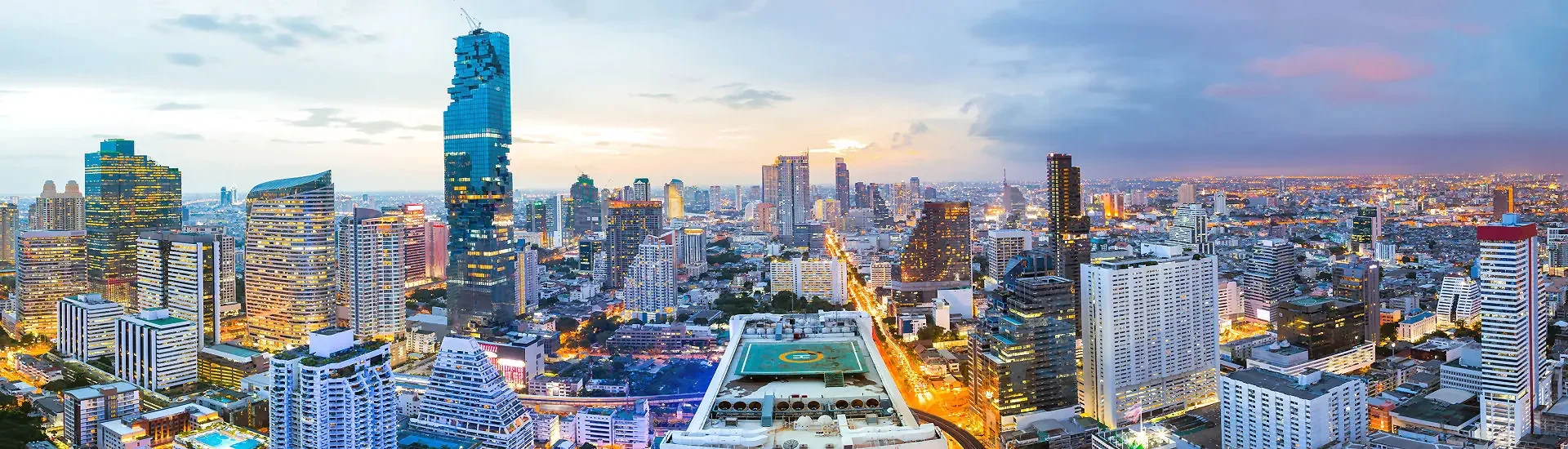 Skyline von Bangkok am Abend mit beleuchteten Hochhäusern und Blick über die Stadt
