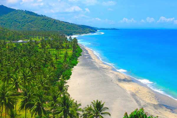 Weite Küste auf Lombok mit Palmen und hellem Sandstrand als Teil einer Indonesien-Reise