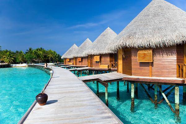Overwater-Bungalows auf den Malediven mit Holzsteg über türkisfarbener Lagune