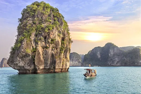 Boot vor Kalksteinfelsen in Thailand bei ruhigem Meer – typische Szene einer Thailand Kombireise