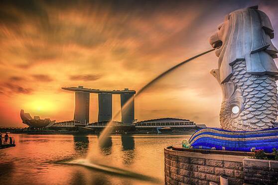 Blick auf den Merlion-Brunnen und die Marina Bay Sands in Singapur bei Sonnenuntergang