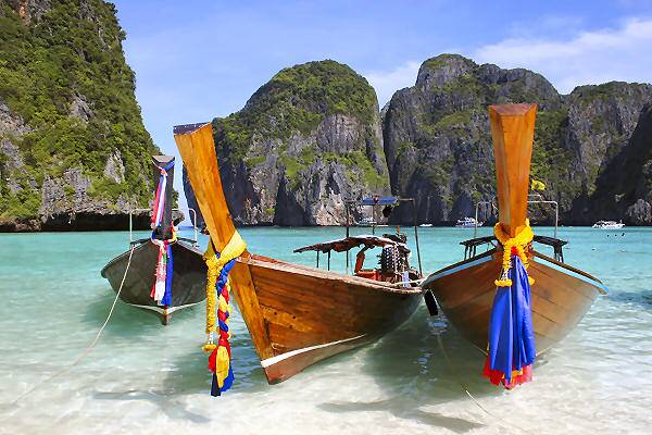 Inselhopping in Thailand mit traditionellen Longtail-Booten an einem tropischen Strand