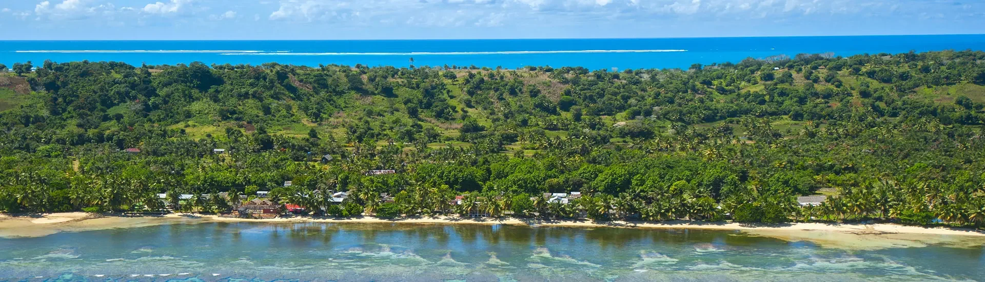 Tropische Küstenlandschaft auf Madagaskar mit Palmen, grünem Hinterland und türkisblauem Meer