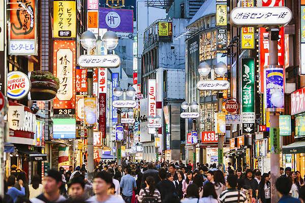 Belebte Einkaufsstraße mit Leuchtreklamen in Osaka, Japan