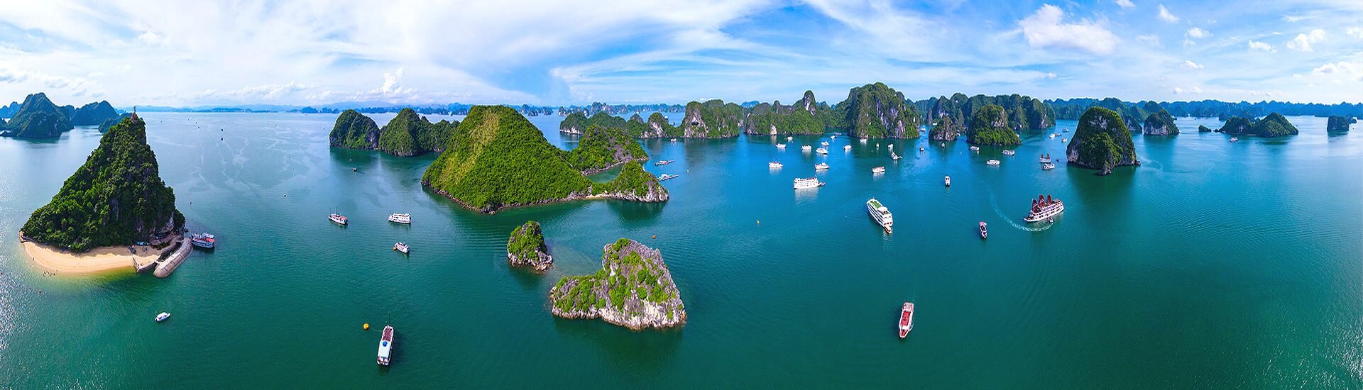 Panorama mit vielen grünen Inseln und Booten in tropischer Meereslandschaft