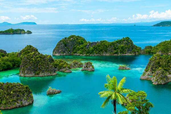 Ausblick auf grüne Inseln und türkisfarbene Lagunen in Indonesien – Inselhopping Indonesien