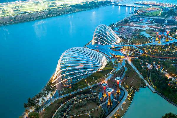 Blick auf Gardens by the Bay und Marina Bay in Singapur bei Abendlicht