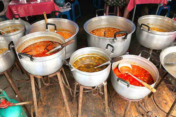Street-Food-Garküchen auf Phuket mit großen Töpfen und thailändischen Currys