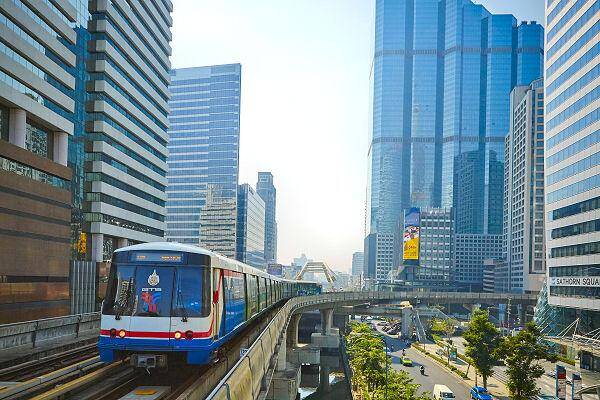 BTS Skytrain in Bangkok zwischen Hochhäusern im Geschäftsviertel nahe Hotels und Bürogebäuden
