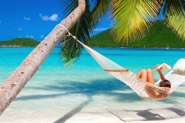 Hängematte unter einer Palme an einem tropischen Strand auf den Seychellen