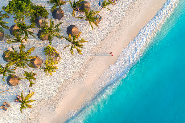 Weißer Sandstrand mit Palmen und türkisfarbenem Meer auf Sansibar