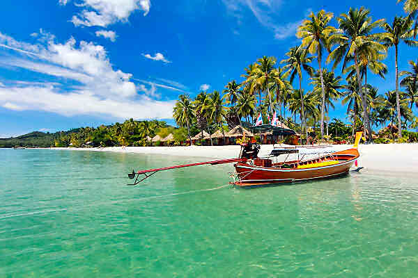 Longtail-Boot vor tropischem Strand in Thailand – Symbol für das Kombinieren mehrerer Inseln