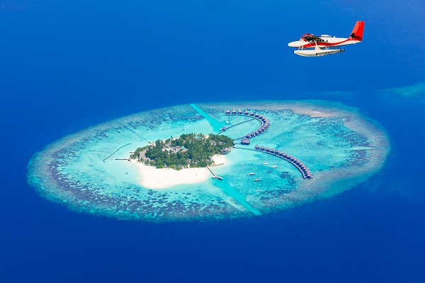 Malediven Insel mit türkisfarbener Lagune und Wasserflugzeug