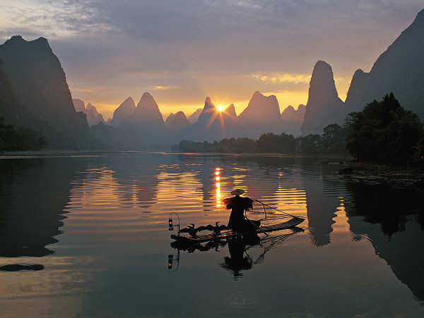 Ein Kormoranfischer mit seinem Bambusfloss auf dem Li Fluss bei Guilin