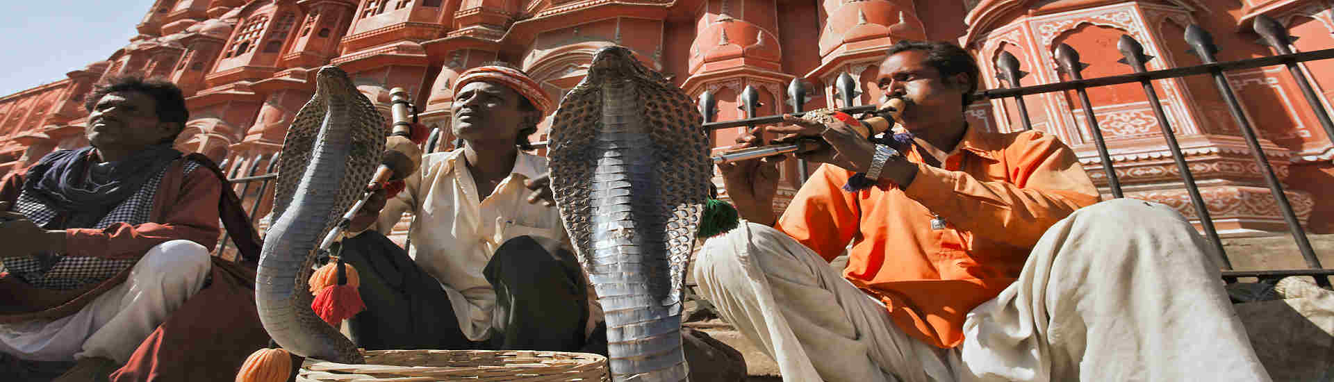 Bild eines Schlangebeschwörers vor dem Palast der Winde in Jaipur, Indien - Authentische indische Kultur erleben