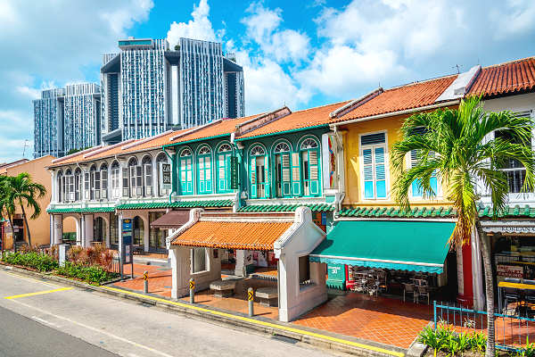 Lebhaftes Treiben in Singapurs Chinatown mit bunten Geschäften, traditionellen Tempeln und dekorierten Straßenlaternen.