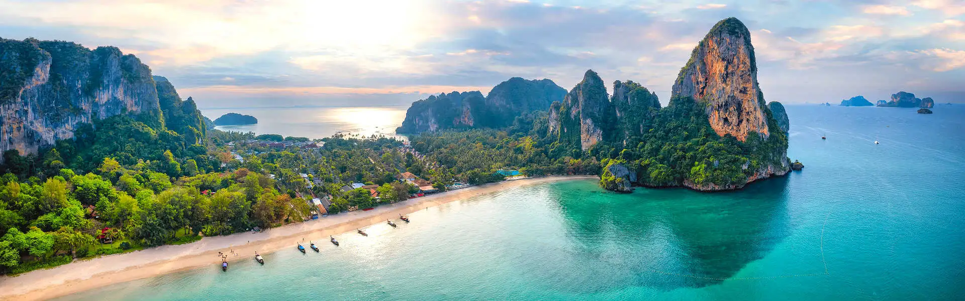 Thailand Reisen mit AsiaGo: Malerische Bucht in Krabi mit türkisblauem Wasser, weißen Sandstränden und imposanten Kalksteinfelsen