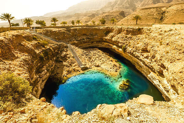 Badestelle Bimmah Sinkhole im Oman Inmitten eines Parks liegt ein strahlend türkisblauer Pool, der der Legende nach durch einen Meteoriteneinschlag entstanden sein soll
