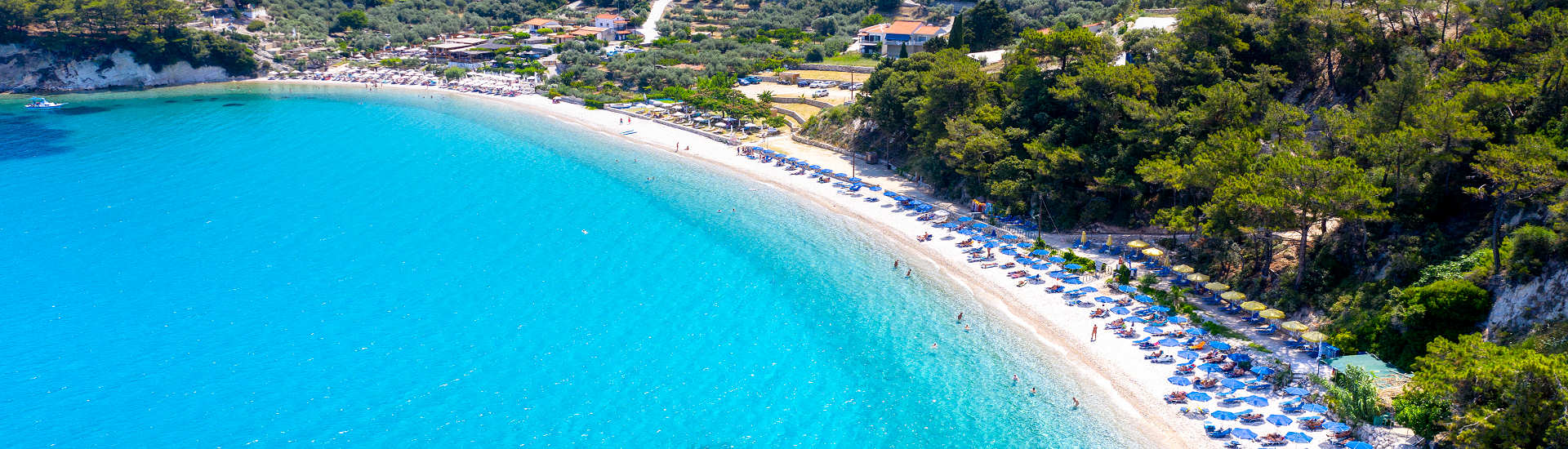Griechenland Urlaub – Entspanne am Tsamadou Beach auf Samos Traumhafter Tsamadou Beach auf Samos mit kristallklarem Wasser und Pinienwald im Hintergrund