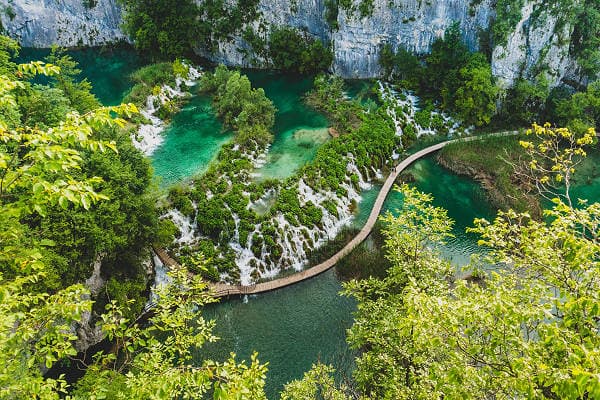 Luftaufnahme des Plitvicer Seen Nationalparks in Kroatien mit kristallklaren Seen, Wasserfällen und Holzstegen inmitten grüner Natur